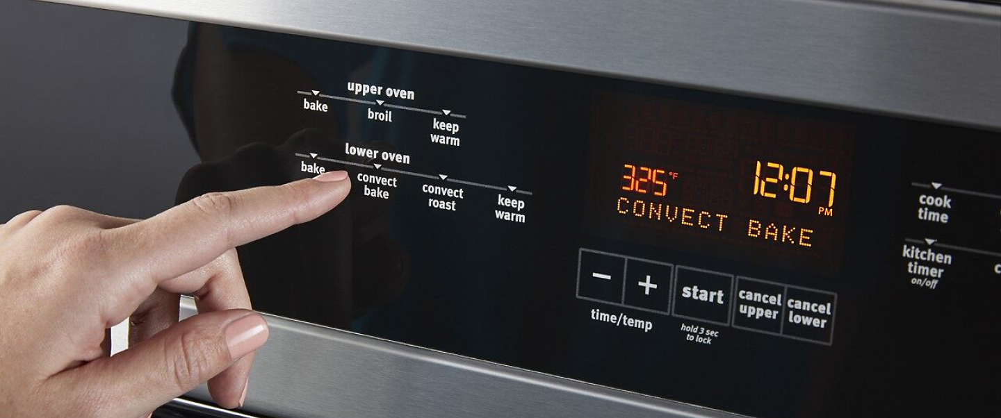 Person selecting an option on a wall oven console