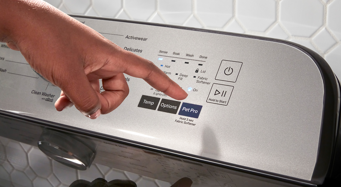 A person selecting the Pet Pro setting on a Maytag® washer.