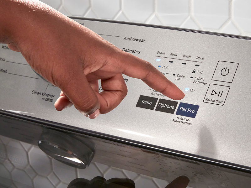 A person selecting the Pet Pro setting on a Maytag® washer.