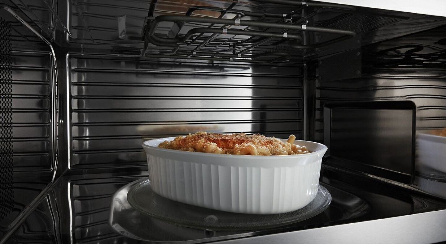  A closeup of the interior of a convection Maytag® microwave cooking a pasta meal.