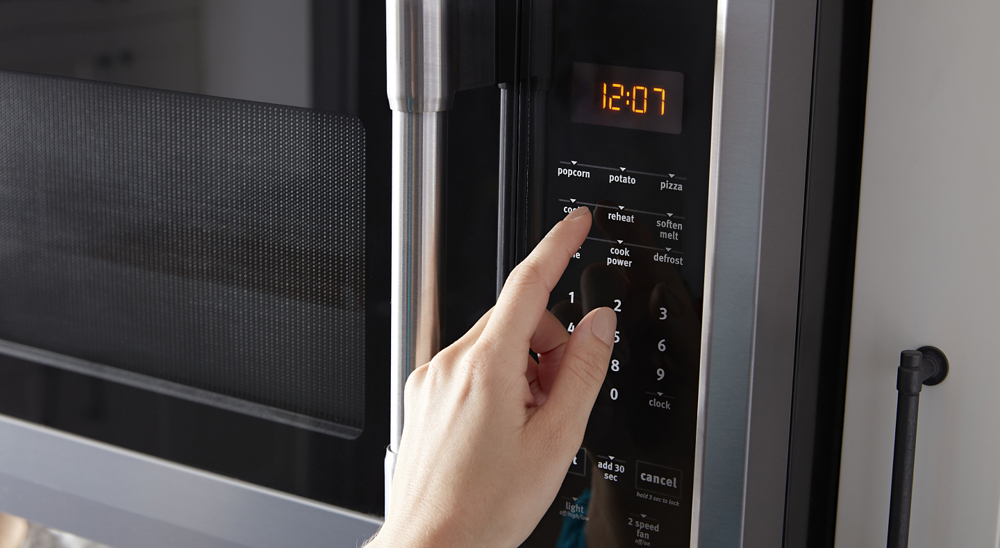 Person selecting settings on a microwave control panel