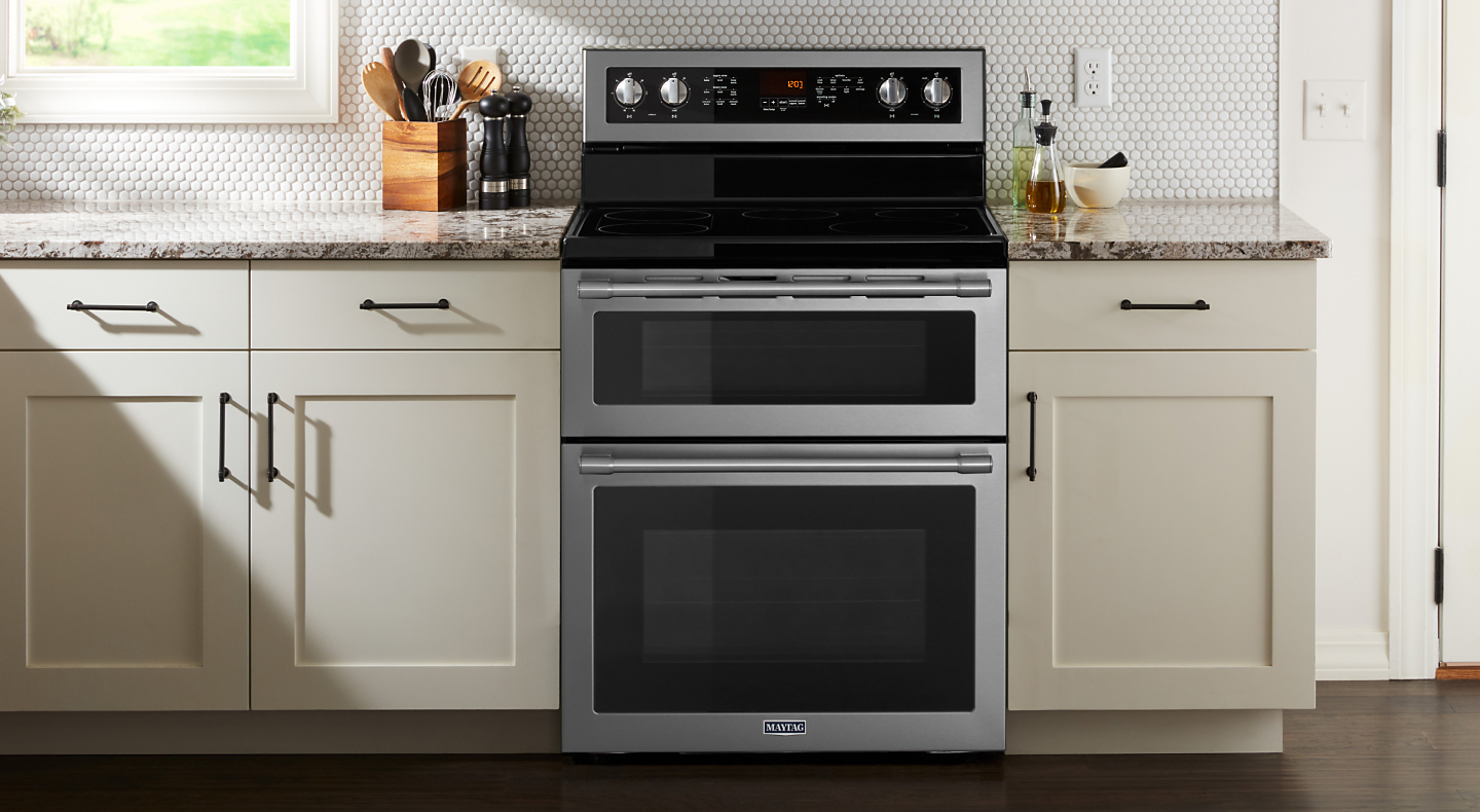 Maytag brand double oven in between white cabinetry 