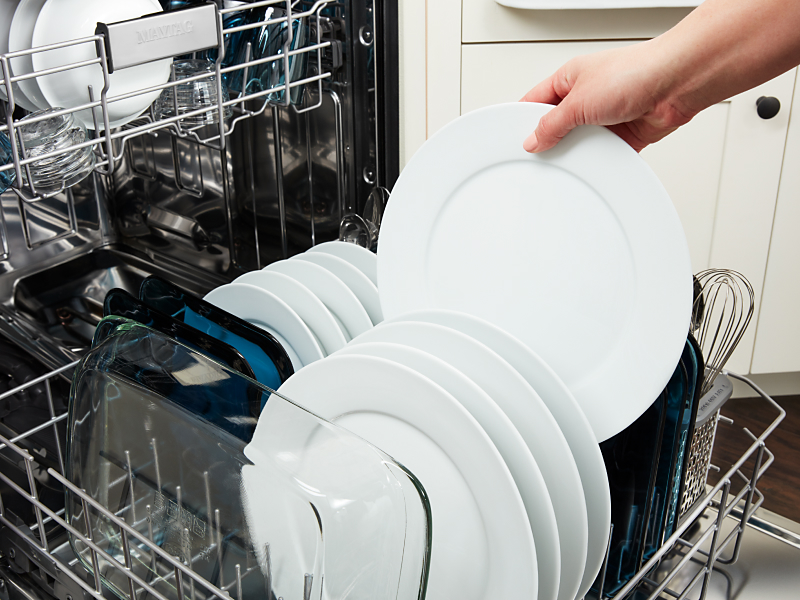 Person putting dishes in a dishwasher
