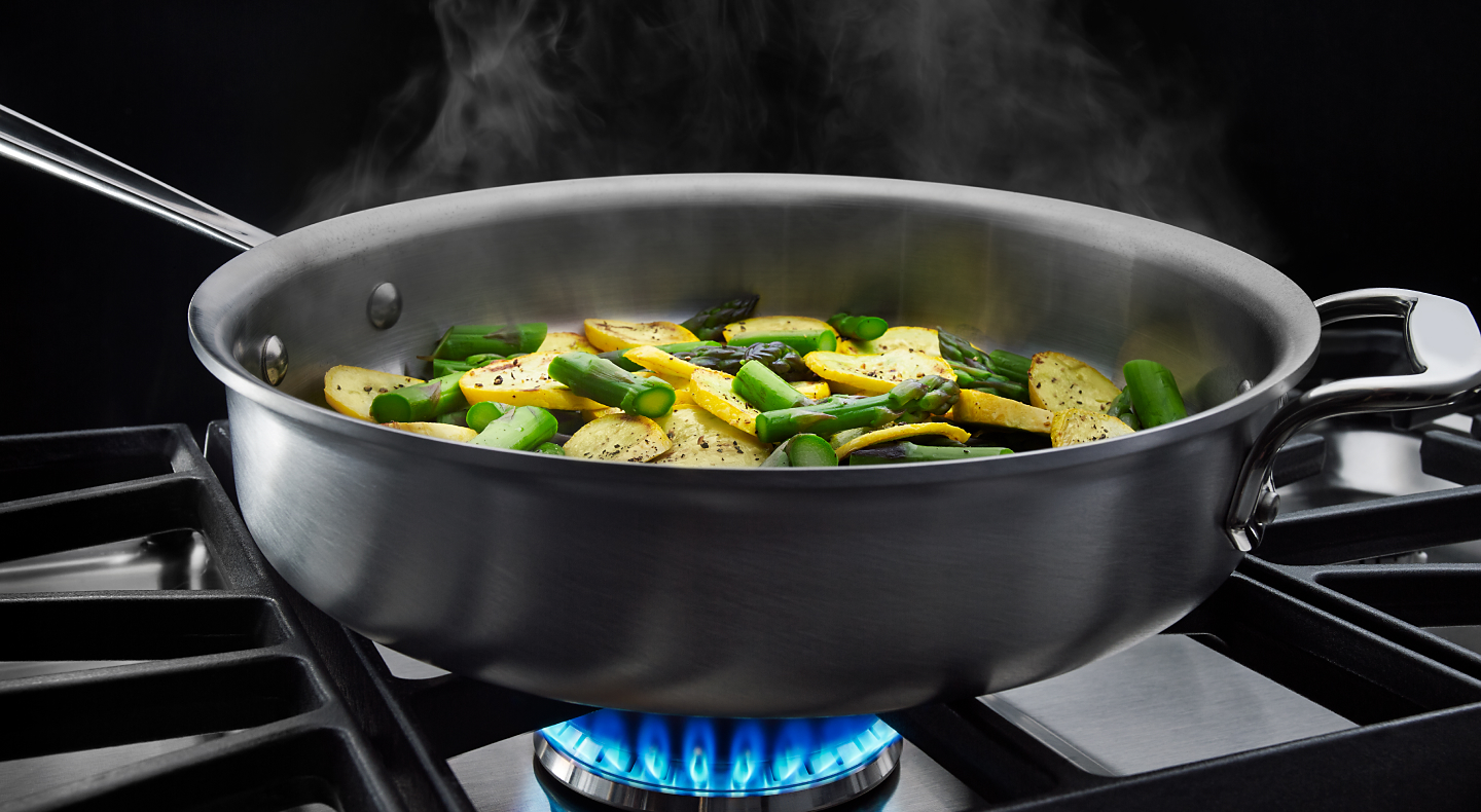 Vegetables cooking in a pan on a gas cooktop