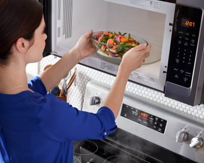 Person putting veggies in the microwave