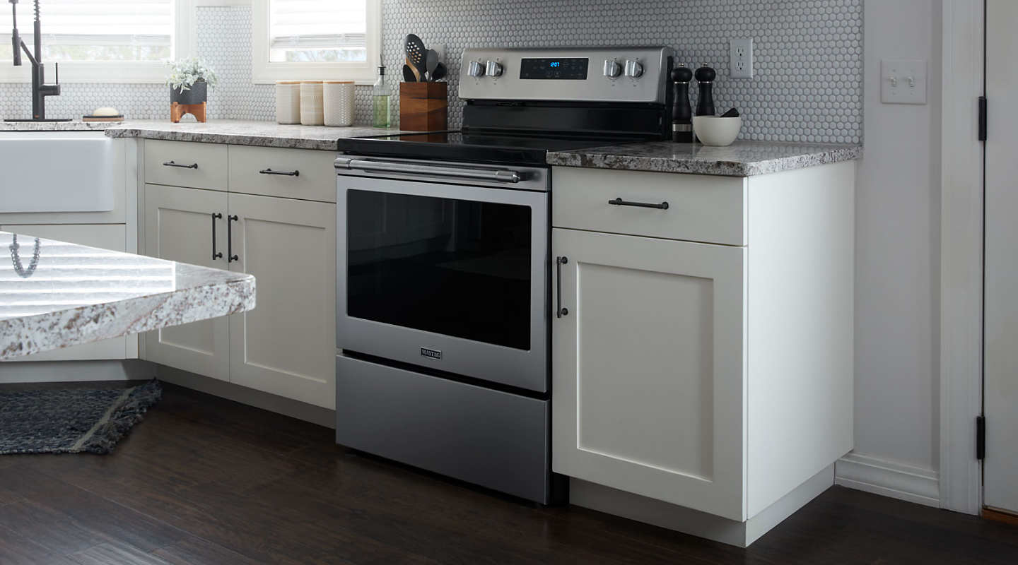 A profile view of a stainless steel Maytag® oven in a contemporary kitchen