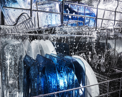 Water running over dishes in dishwasher