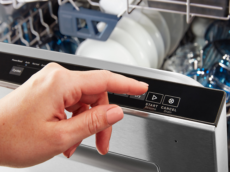 Person pressing start on dishwasher