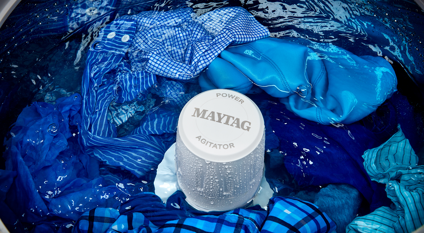 The agitator of a Maytag® Top Load Washer surrounded by wet laundry