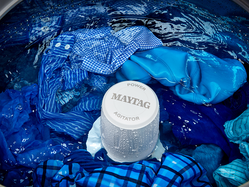The agitator of a Maytag® Top Load Washer surrounded by wet laundry