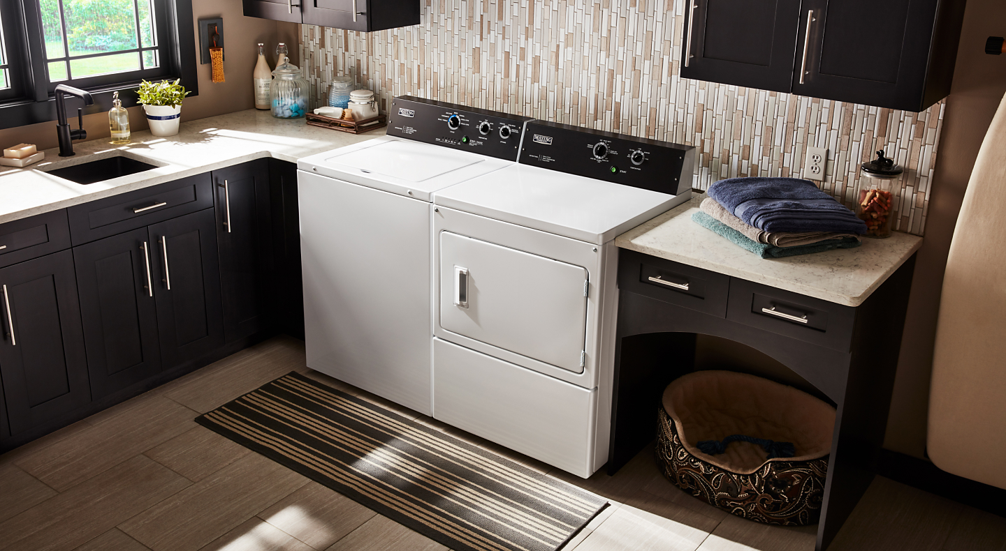  Maytag® Top Load Washer and Front Load Dryer in a laundry room