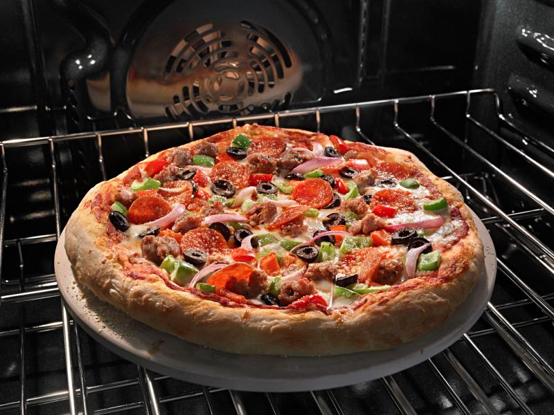 A pizza baking on an oven rack.