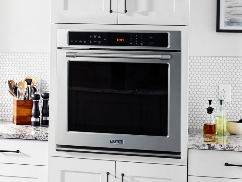 A Maytag® wall oven surrounded by white cabinetry.