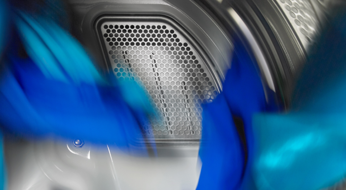 Blue clothes tumbling in a dryer.