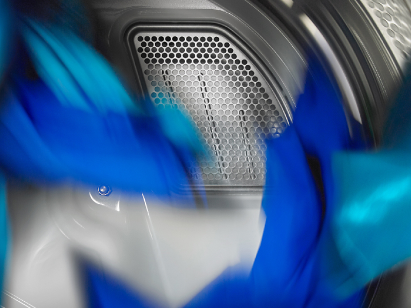 Blue clothes tumbling in a dryer.