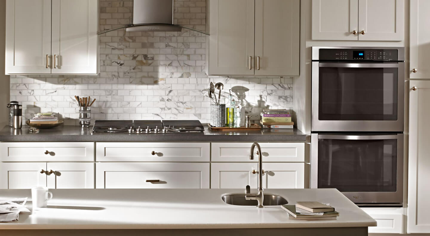 Range hood with a glass canopy above a gas stovetop