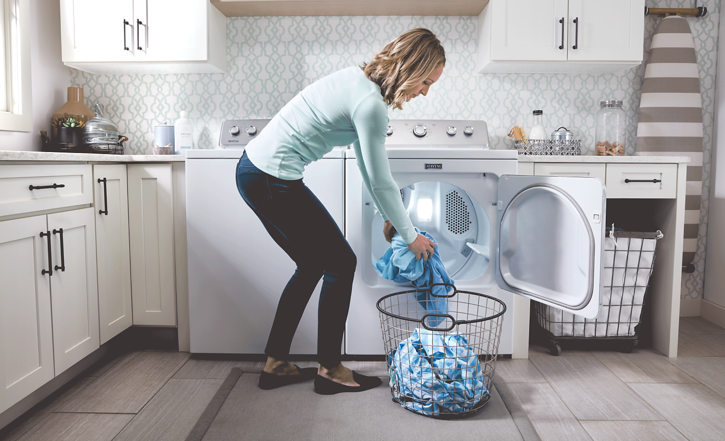 Person transferring items out of a dryer into a basket