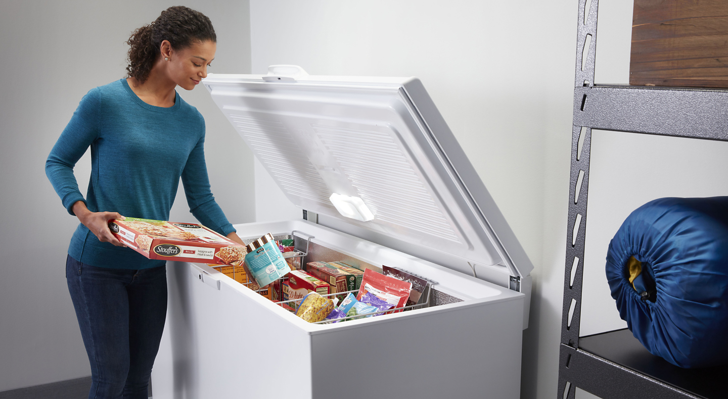 Person putting food in a freezer