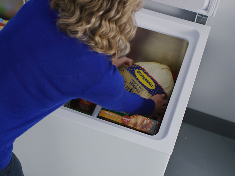 Person placing turkey in a freezer