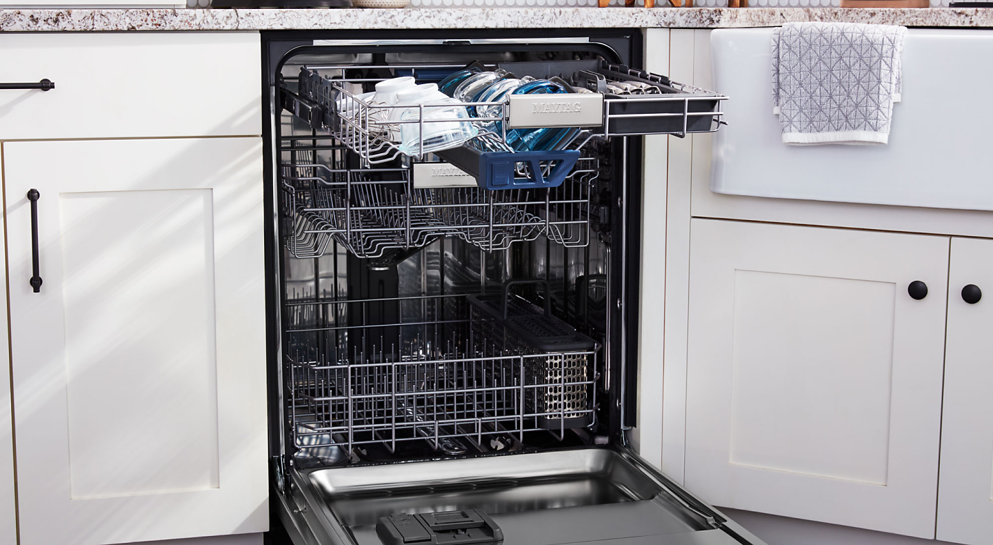Open Maytag® dishwasher with dishes on the top rack