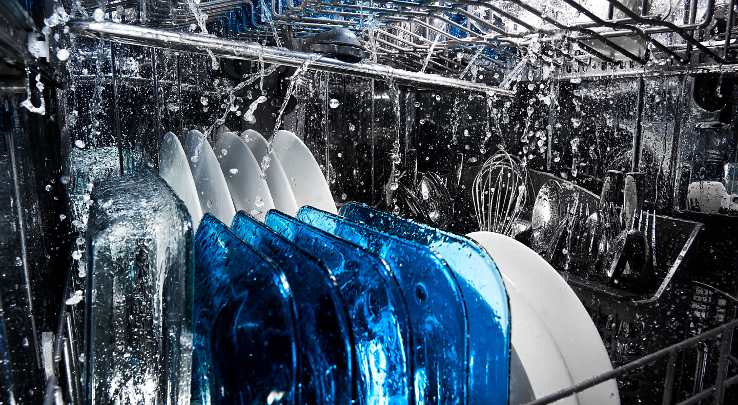 Dishes being run through a dishwasher wash cycle