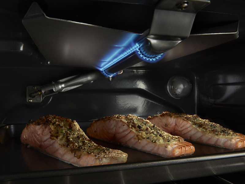 Three salmon filets cooking inside a Maytag® oven