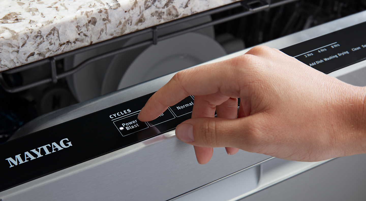 Person selecting the PowerBlast® cycle on a Maytag® dishwasher