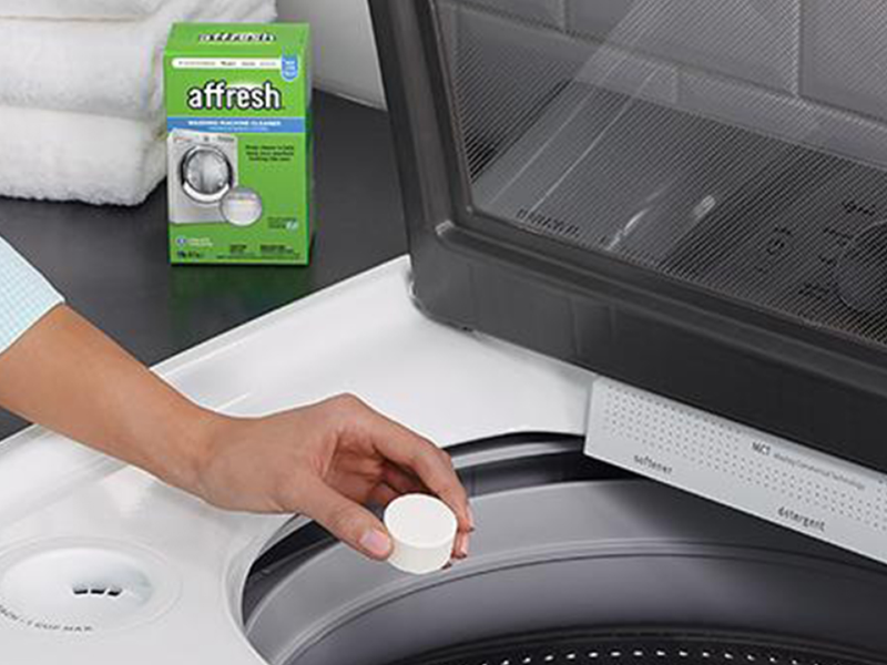Person placing affresh® tablet in washing machine
