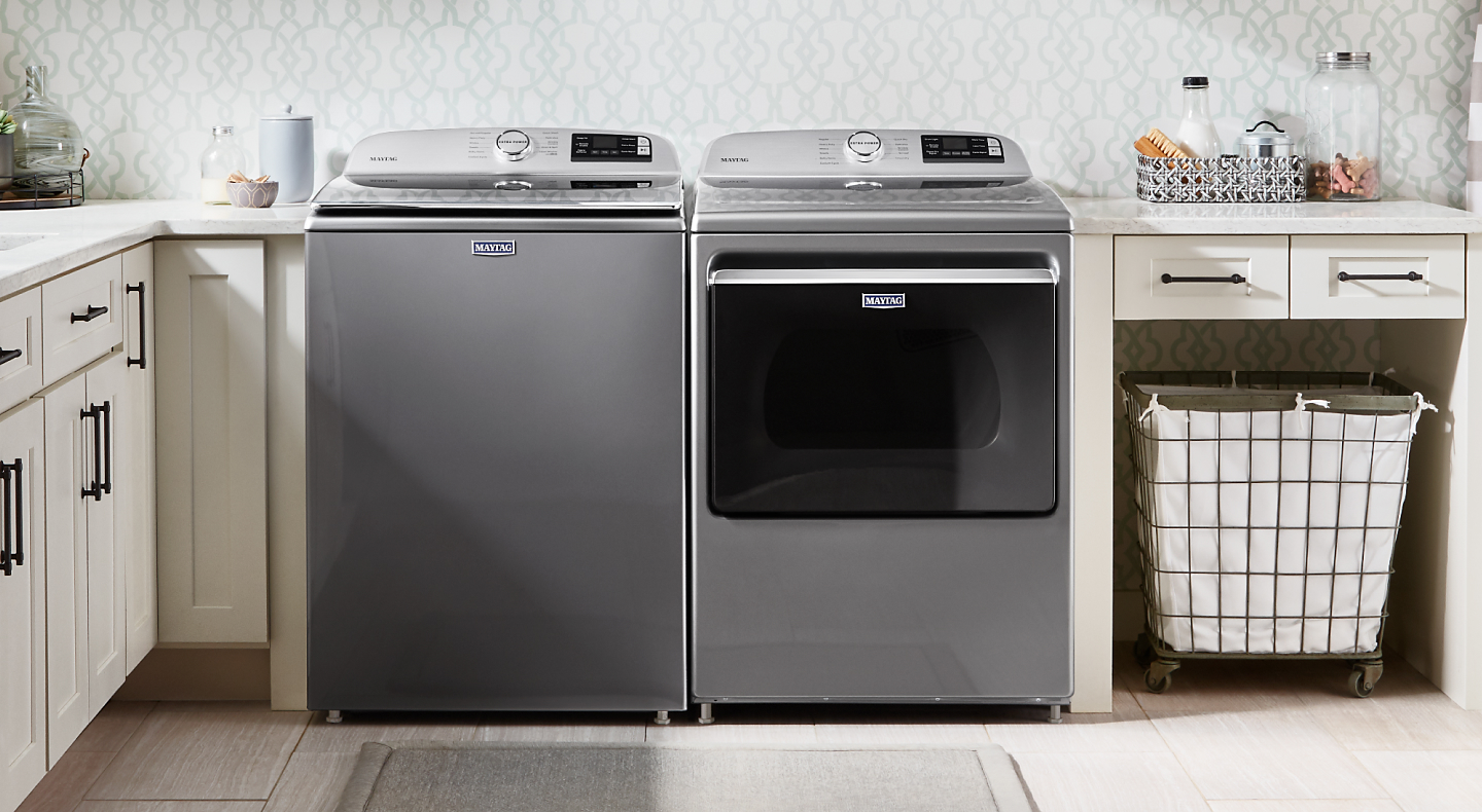 Stainless Maytag® top load washer and front load dryer side by side in a tidy, bright laundry room