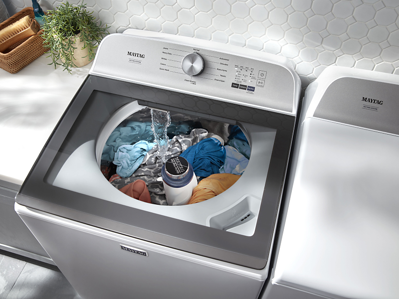 Clothes inside a white Maytag® top load washer