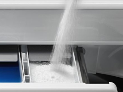 Tight shot of powder detergent pouring into washing machine