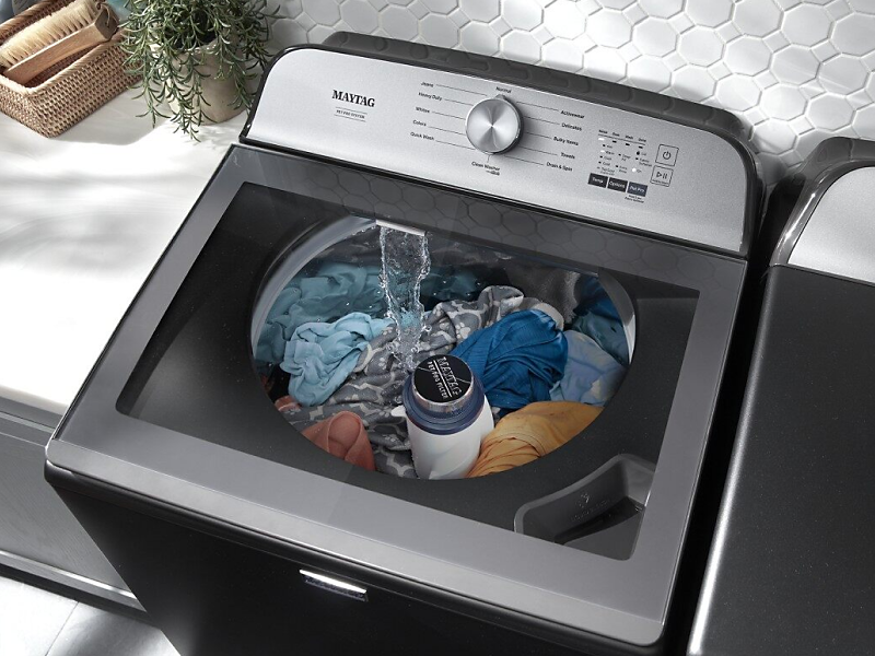 Overhead view of top-load washer filled with laundry