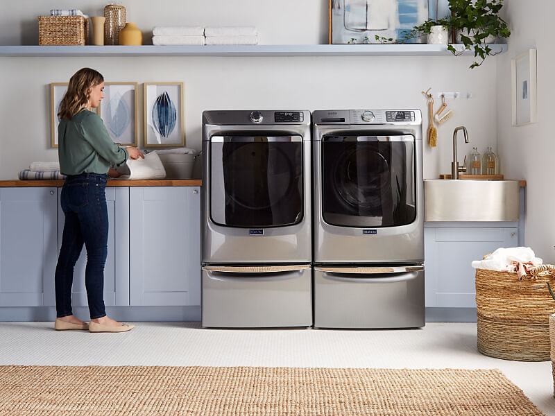 Person standing next to Maytag® laundry pair.