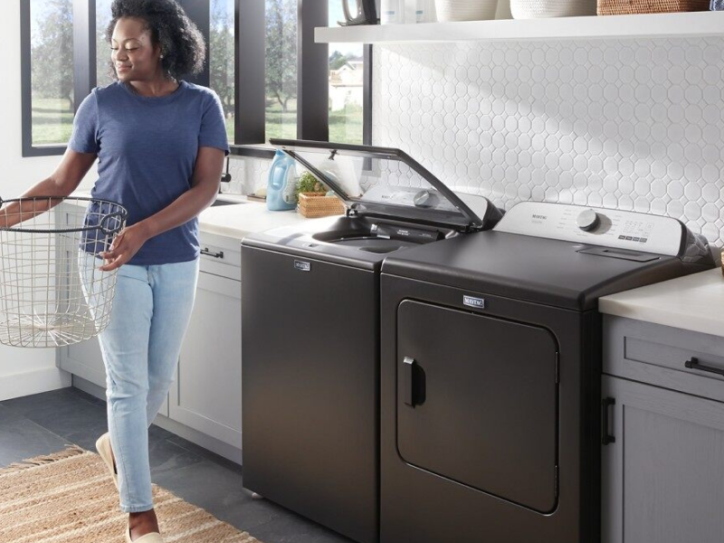 Woman standing next to open washer and dryer set