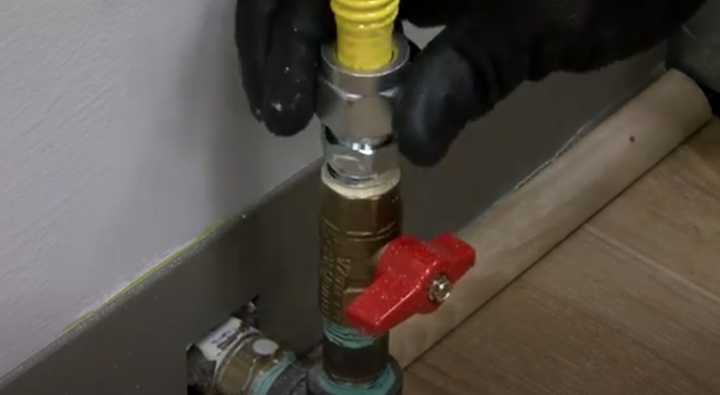 A closeup of a gas stove connector