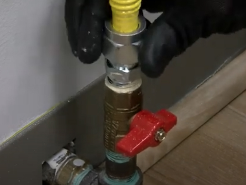 A closeup of a gas stove connector