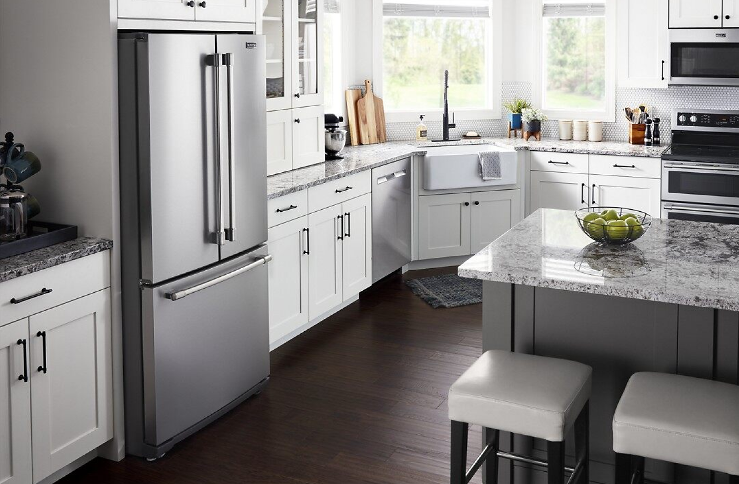 Open kitchen with a French door refrigerator, white cabinets and kitchen island