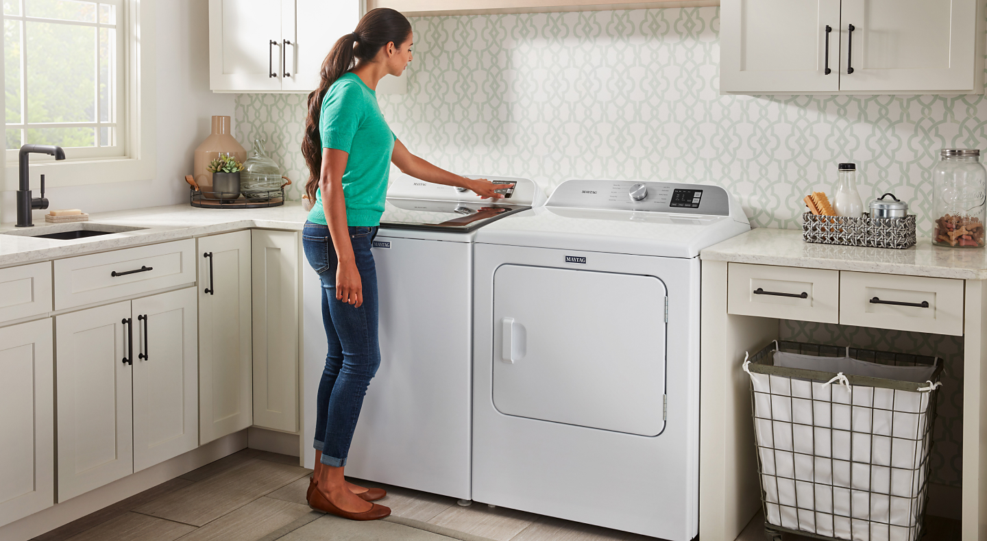 A woman selecting an option on her Maytag® washing machine. A woman selecting an option on her Maytag® washing machine.