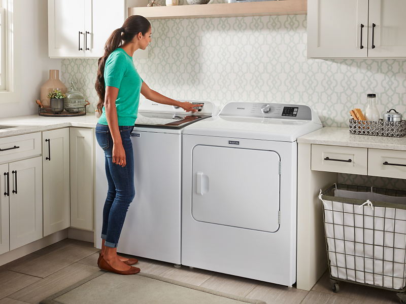 A woman selecting an option on her Maytag® washing machine. A woman selecting an option on her Maytag® washing machine.