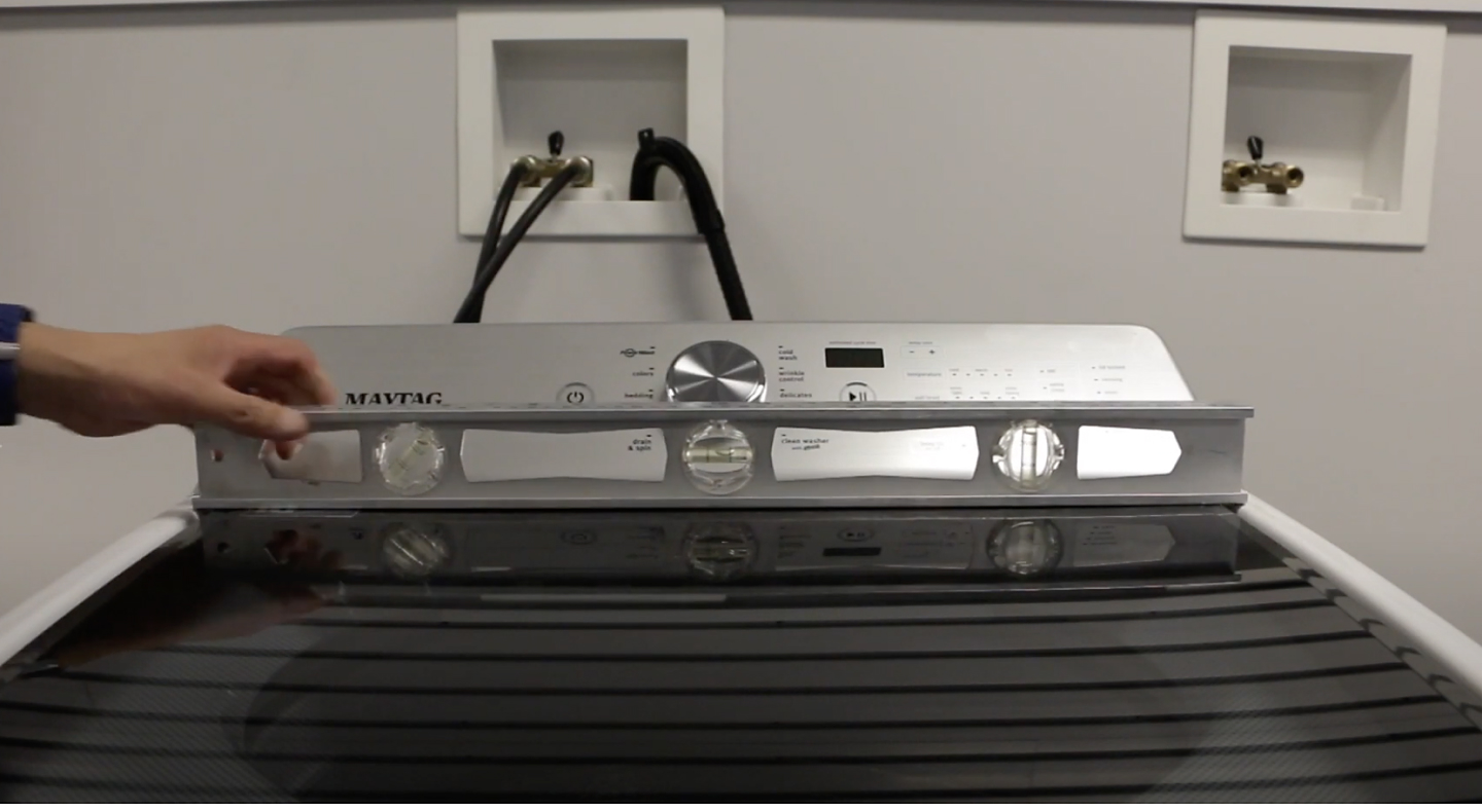 A man checking the levelness of a Maytag® washing machine. A man checking the levelness of a Maytag® washing machine.
