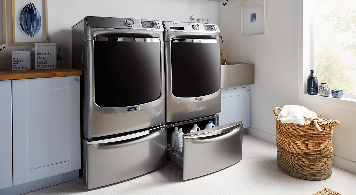 Maytag® washer and dryer on pedestals in a modern laundry room