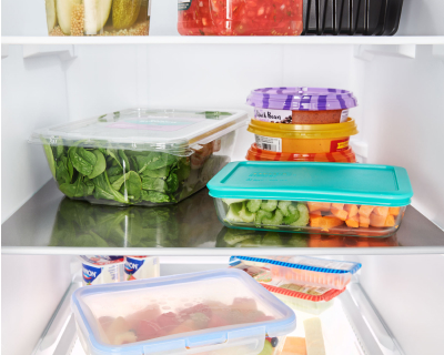 Containers of fresh ingredients stored on fridge shelves