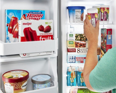 A woman removing an item from a side-by-side fridge freezer compartment