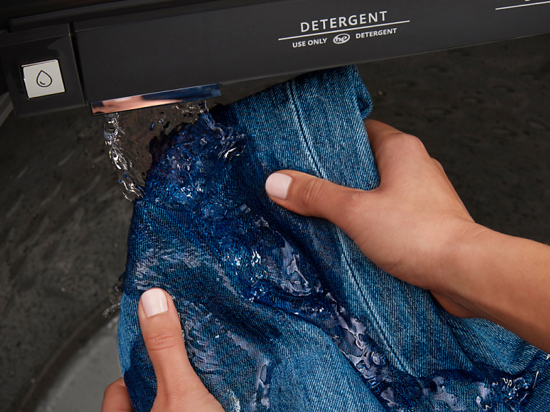 Person rinsing jeans in a Maytag® washer