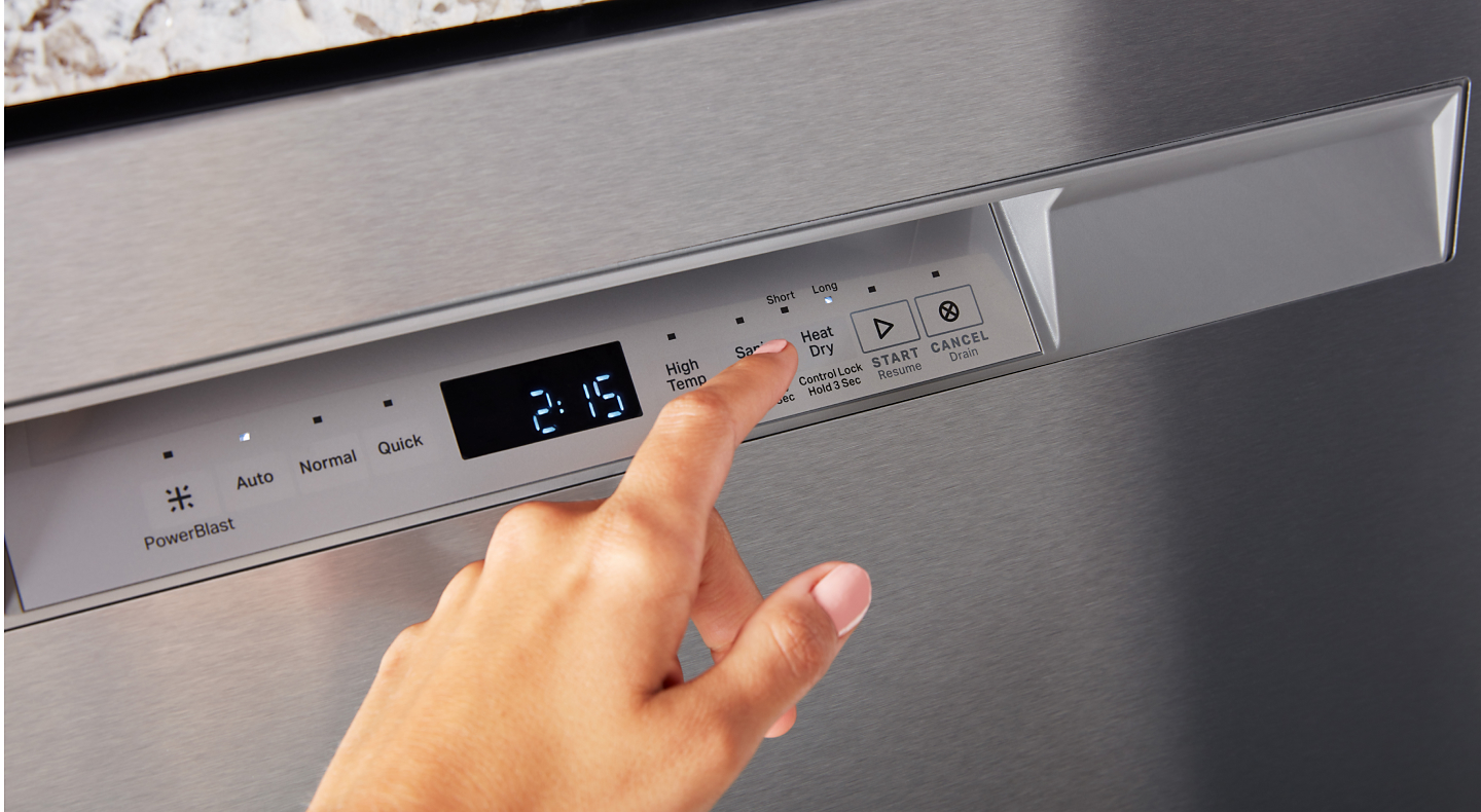 Finger hovering over control panel on stainless steel dishwasher