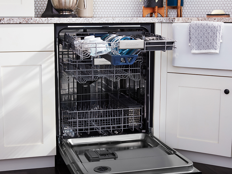 Dishwasher with door open showing washed dishes on racks
