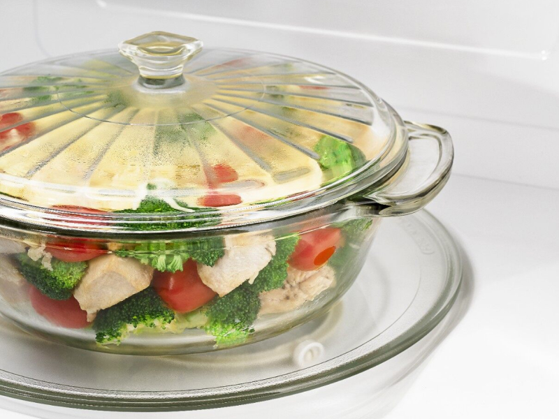 A closeup of a glass bowl of steaming vegetables in a Maytag® microwave