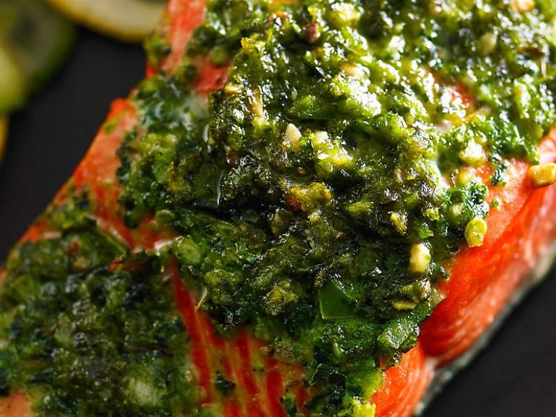 Closeup of cooked fish garnished with pesto