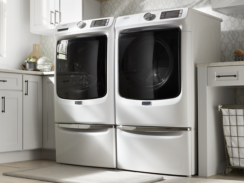 White front load laundry pair in a white laundry room