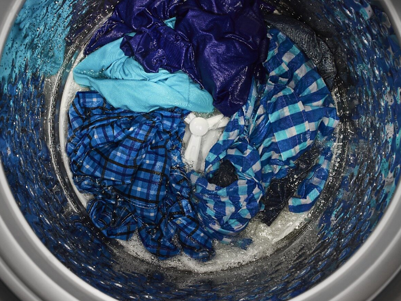 Blue clothes in the bottom of an impeller washer